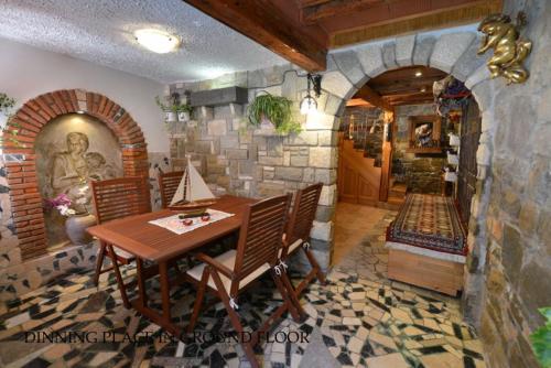 皮兰Vila Nada Piran的一间设有桌子和石墙的用餐室