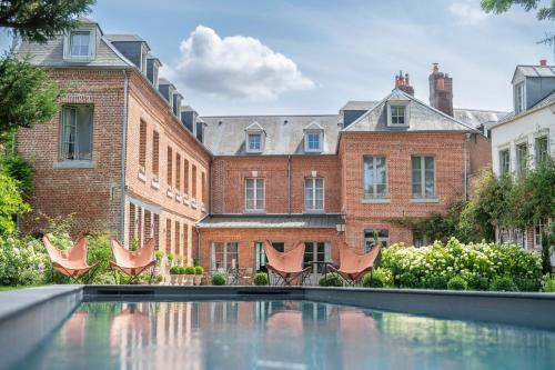 阿布维尔les Myrrhophores et Spa, Chambres d'Hôtes et Gîtes de charme的建筑前带游泳池的庭院