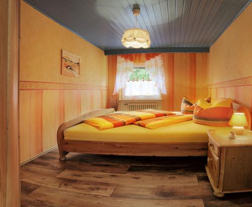 HildersFerienwohnung Rhönblick的一间卧室配有一张大床,提供黄色和橙色枕头
