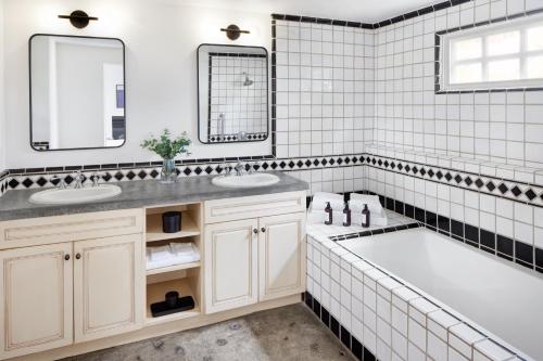 扬特维尔薰衣草四姐妹旅馆的白色的浴室设有2个盥洗盆和1个浴缸。