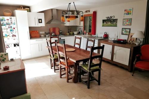 博迪昂La maison de la vigne的厨房配有木桌和椅子