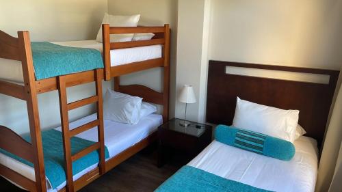 拉塞雷纳Hotel y Departamentos La Serena - Caja Los Andes的小房间设有两张双层床和一张床