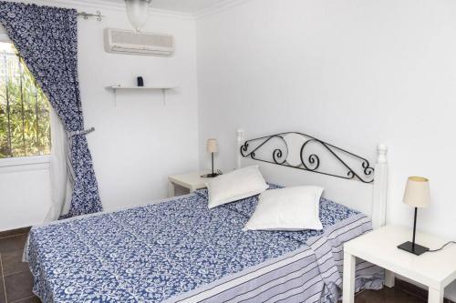 博德鲁姆Comfortable Triplex 5 Min to the Beach with Garden in Bodrum的卧室配有蓝色和白色的床和2个枕头