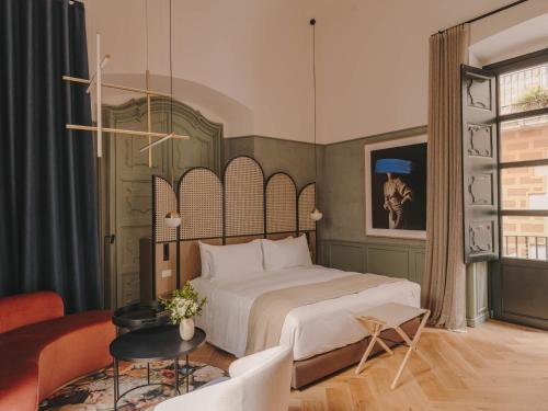 赫罗纳Hotel Palau Fugit的一间卧室设有一张床和一间客厅。