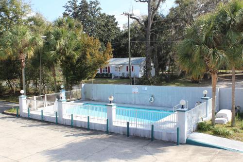 盖恩斯维尔盖恩斯维尔旅行者酒店的游泳池周围设有白色围栏