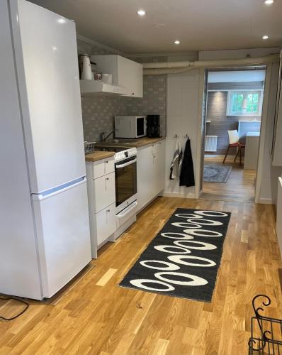 卡尔斯克鲁纳Holiday Apartment, Bergåsa的厨房配有白色冰箱和厨房地毯。