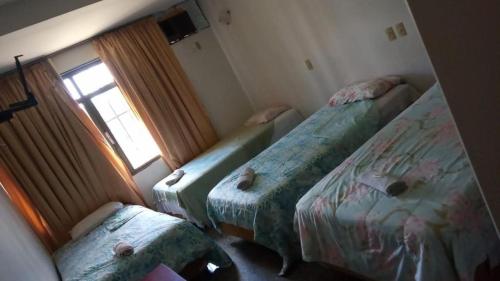 巴西利亚Beiruth Hotel的带三张床和窗户的客房