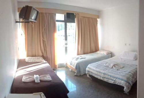 巴西利亚Beiruth Hotel的酒店客房设有两张床和电视。