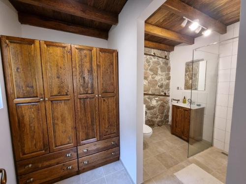 Deredzhik-KʼoyWalnut Cottage 1的一间带木制橱柜、卫生间和淋浴的浴室。