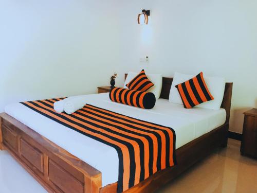 锡吉里亚锡吉里亚拉纳欣格自然别墅的一间卧室配有一张带条纹床单和枕头的大床