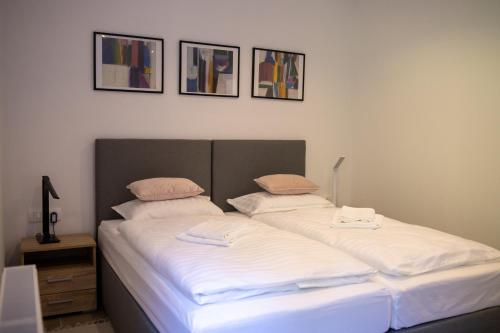 代尔尼采Apartmani Vukman的一间卧室配有两张带白色床单和枕头的床。