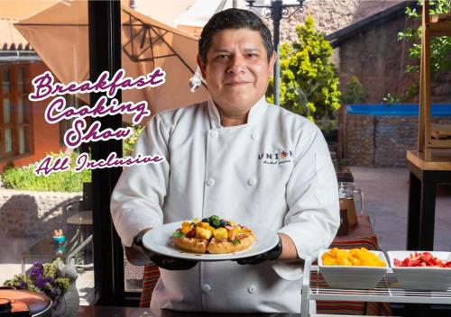 库斯科Union Hotel Cusco的厨师正在拿着一盘食物
