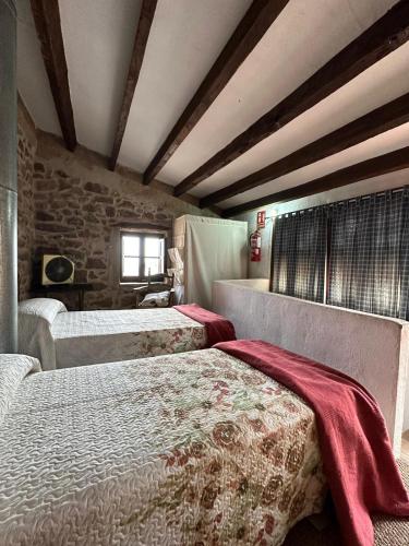 比拉法梅斯Casa Castillo的一间卧室设有两张床和石墙