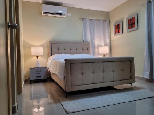LiceyApto Entero familiar espacioso con piscina confortable的一间卧室配有一张床、两盏灯和一个窗户。