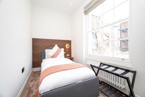 伦敦3 Bedroom flat with Terrace in Central London的一间卧室设有一张床和一个窗口