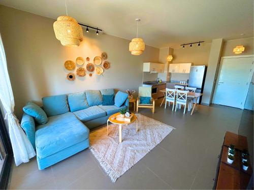 赫尔格达Lily's Place - Scenic Lagoon View at Tawila, Gouna的客厅配有蓝色的沙发和桌子