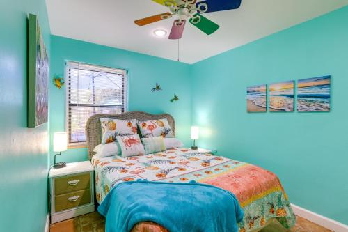 圣彼得堡Colorful Gulfport Home Walk to the Art District!的蓝色卧室配有床和吊扇