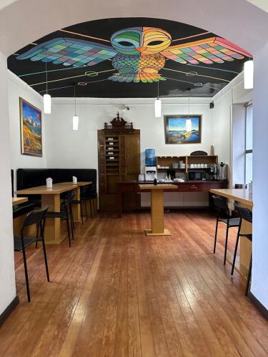 拉巴斯El Museo Hotel Boutique的客房设有桌椅和色彩缤纷的天花板。