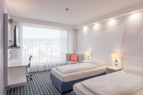 阿福尔特恩阿福尔特恩阿尔比斯智选假日酒店的酒店客房设有两张床和窗户。