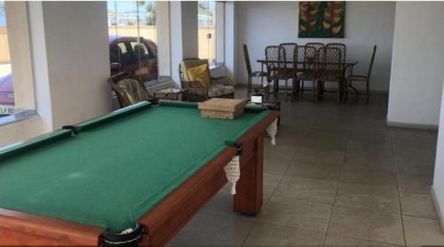 卡拉瓜塔图巴Riviera Massaguaçu 23的客厅配有台球桌和椅子