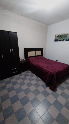 La UniónHostel la abuela的卧室配有红色的床,铺有瓷砖地板。