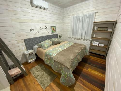 乌鲁比西Chalé Terra Luni的一间卧室设有一张床和一个书架