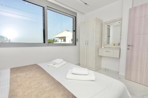 乌尔齐尼NESI Apartments的白色的卧室设有床和窗户