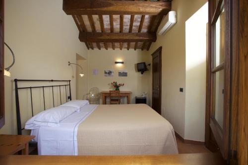 萨杜勒尼亚Bio Agriturismo Il Torrione的卧室配有白色的床和桌子