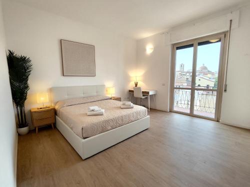 奥尔比亚Attico Vespucci Luxury Penthouse的白色的卧室设有床和大窗户