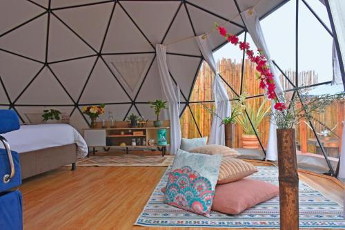 瓜塔维塔Glamping Claro de Luna的一间卧室,配有带一张床和花瓶的帐篷