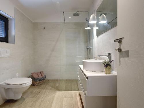 普拉Modern villa swimming pool , outdoor kitchen and fenced garden的白色的浴室设有卫生间和水槽。