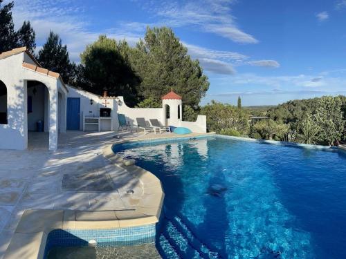 Pouzols-MinervoisModern villa with private pool的一座房子前面的蓝色海水游泳池