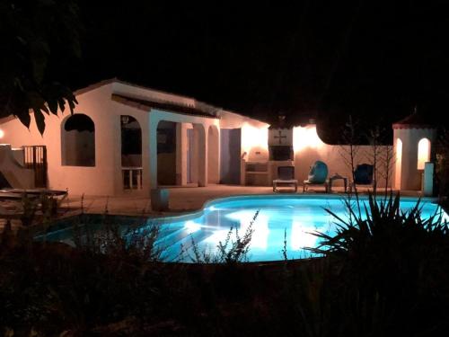 Pouzols-MinervoisModern villa with private pool的夜间在房子前面的游泳池