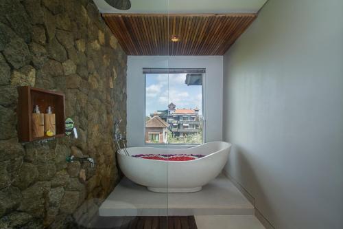 乌布The Runik Ubud的带浴缸的浴室和窗户