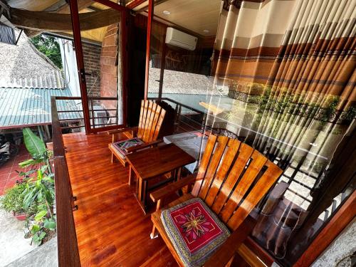 Yên Bình弗林家庭民宿的阳台设有2把椅子和1张桌子,门廊上设有