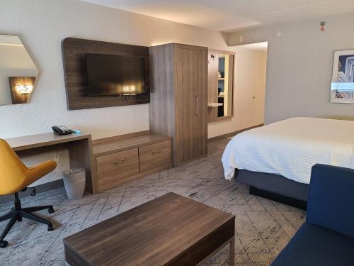 劳德代尔堡劳德代尔堡北 - 行政机场智选假日酒店的酒店客房配有一张床、一张书桌和一台电视。