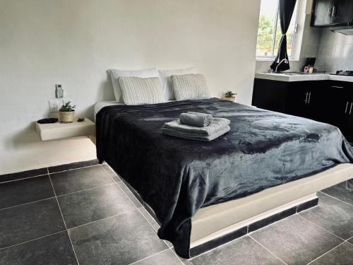 奥尔沃克斯岛Casa Tsunuum的一间卧室配有一张大床和黑色毯子