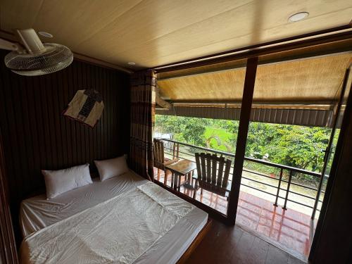 Yên Bình弗林家庭民宿的一间卧室设有一张床,享有阳台的景色