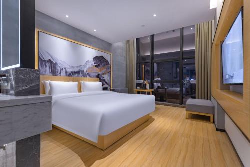 温州途客中国酒店（温州汽车南站店）的卧室配有一张白色大床和电视。