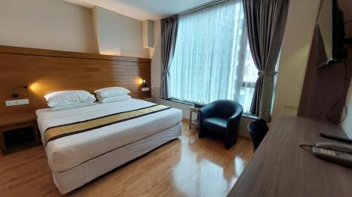 仰光Hotel Grand Galaxy的配有一张床、一张书桌和一扇窗户的酒店客房