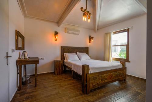 切什梅Belong Butik Otel的一间卧室配有一张床、一张桌子和一个窗户。