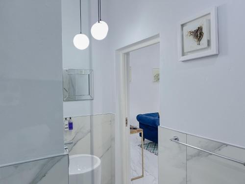 约翰内斯堡Amoris Guesthouse - In Randburg的带淋浴和蓝色椅子的白色浴室