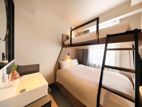 福冈QuintessaHotel FukuokaHakata Relax&Sleep的一间卧室设有两张双层床和水槽