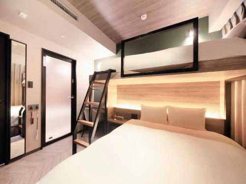福冈QuintessaHotel FukuokaHakata Relax&Sleep的一间卧室配有一张床,楼上配有电视