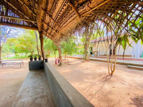锡吉里亚Ima Villa Sigiriya的公园里种有树木和长凳的亭子