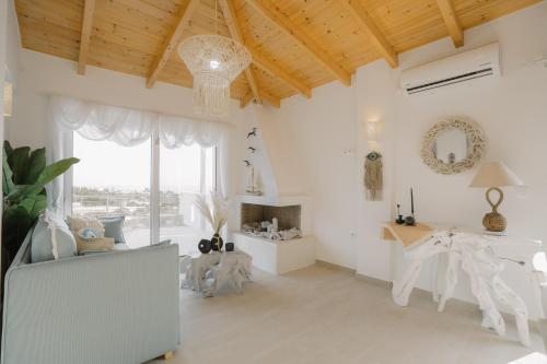卡利斯托斯MIRAMAR KARYSTOS的客厅拥有白色的墙壁和木制天花板。