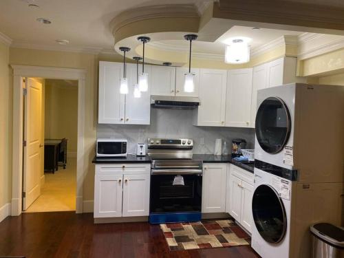 温哥华spacious modern new suite的厨房配有白色橱柜和炉灶烤箱。