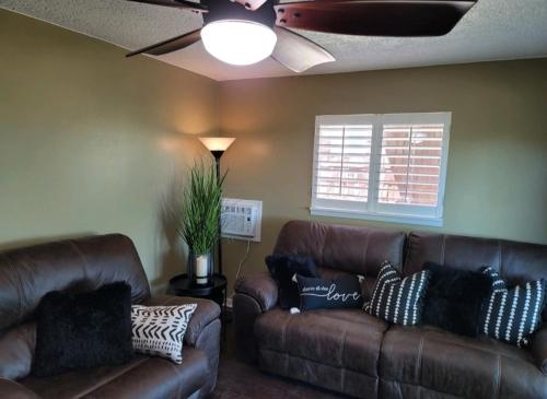 科迪Mountain View Lodging Cody的客厅配有2张棕色皮革沙发和窗户