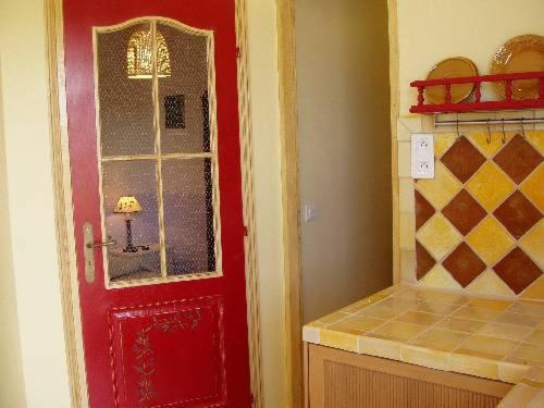 弗雷瑞斯Un petit paradis en Provence的厨房里设有一扇红色门,窗户