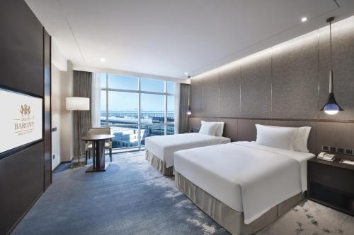 青岛青岛国际机场君廷酒店的酒店客房设有两张床和电视。